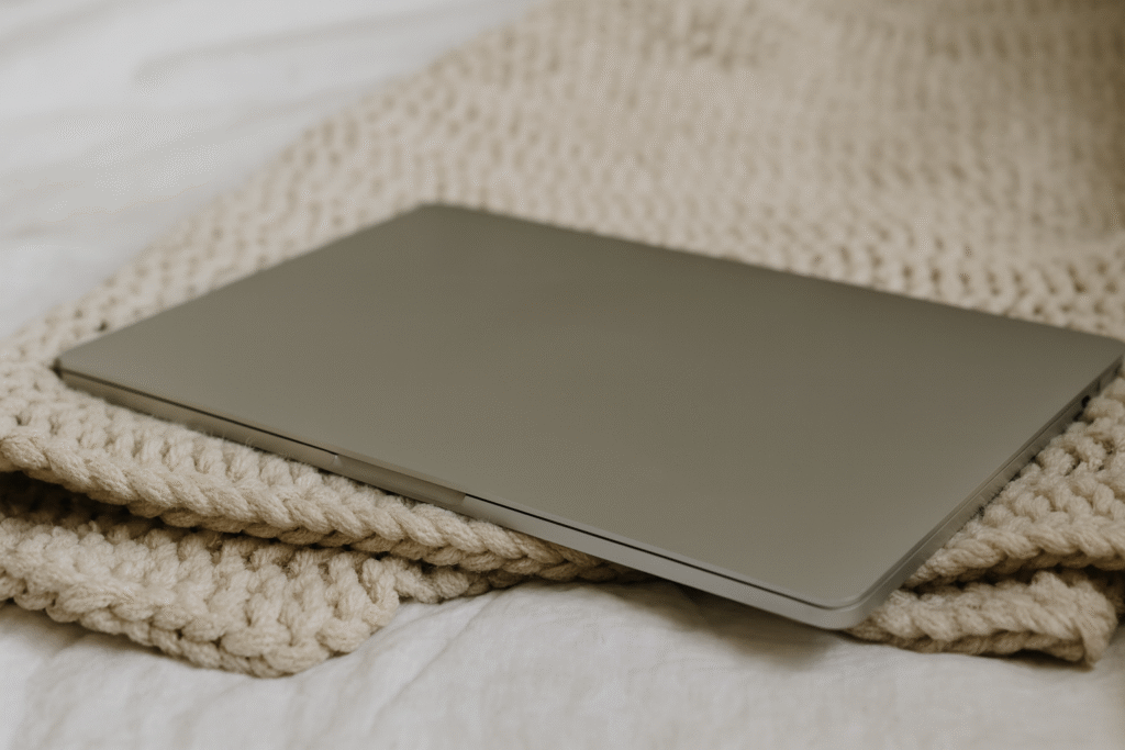 Laptop sitting on a blanket.